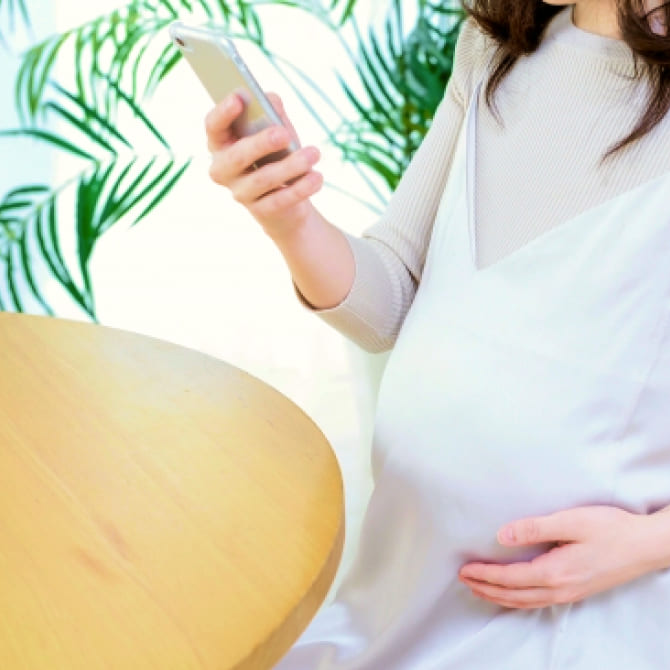 スマホを見ている妊婦